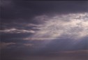 sun rays of inspiration streak in background, scenic photography image of clouds above purple sky